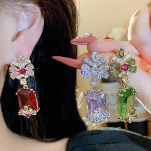 Detailed view of sparkling zircon palace style drop earrings in red, white and green