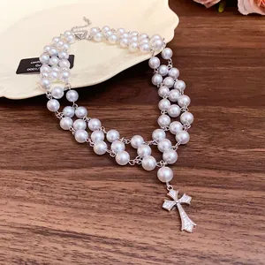 Detail of vintage double-layer pearl necklace with zircon-encrusted cross pendant