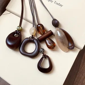 Close-up of retro irregular oval pendants on brown wax cords over a cream box