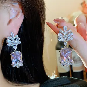 Close-up of elegant silver earrings with rectangular lavender gems and zirconia