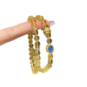 Elegante pulsera de doble capa de cristal champán con una piedra central azul vibrante.