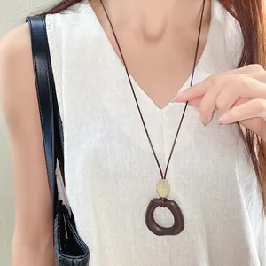 Close-up of a retro new Chinese style necklace with an irregular oval wood-like pendant.