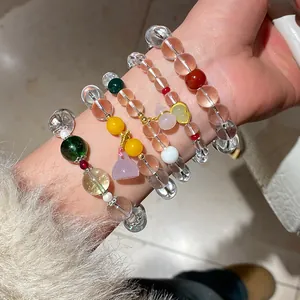 Primer plano macro de varias pulseras apiladas de cuarzo fresa y cuarzo fantasma