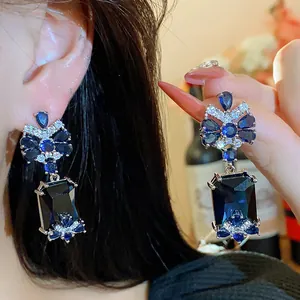 Close-up of elegant blue zircon square dangle earrings in luxury palace style