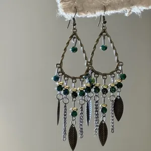 Detailed view of vintage ethnic teardrop tassel earrings with green crystal beads