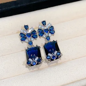 Detailed macro view of luxury vintage style square blue zircon drop earrings with silver pins