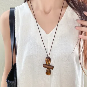 Close-up of a vintage new Chinese style necklace with irregular amber-tone oval pendant.