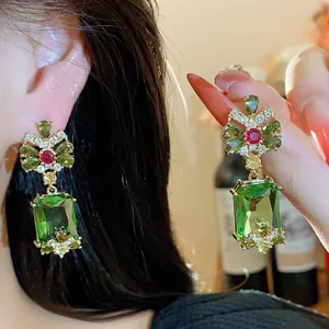 Detailed macro view of vintage green square zircon drop earrings with elegant bow design