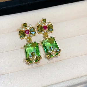 Close-up of vintage style drop earrings with rectangular green cubic zirconia stones