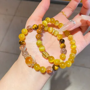 Primer plano de elegantes pulseras de cuentas de ojo de gato amarillo y ojo de tigre