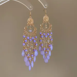 Elegant purple bead tassel drop earrings with golden hollow design for a chic vacation look