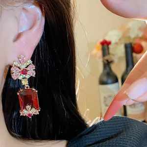 Detail of elegant court style earrings with pink zircon and red square gemstone