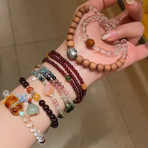 Vista detallada de pulseras de cuentas de cuarzo fresa y fantasma púrpura en la muñeca