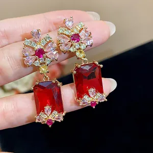 Detailed view of royal court style earrings with vibrant red and pink zircon stones.