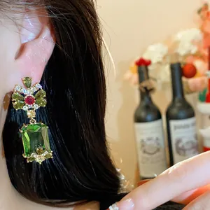 Detailed close-up view of elegant court-style earrings with green square zircon drop