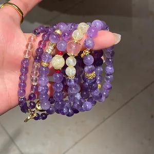 Primer plano de pulseras de cuentas de cuarzo fantasma púrpura y cristal de fresa