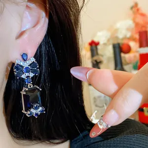 Close-up detail of royal style zircon drop earrings featuring a sparkling rectangular blue stone.