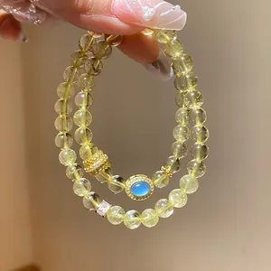 Vista detallada de una elegante pulsera de doble capa de cuentas amarillas con dije de gema azul