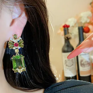 Close-up of vintage emerald green rectangle dangling earring with multicolor zircon flower detail