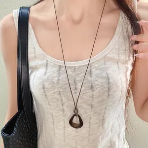 Retro irregular oval pendant necklace with long wax cord shown on a female model.