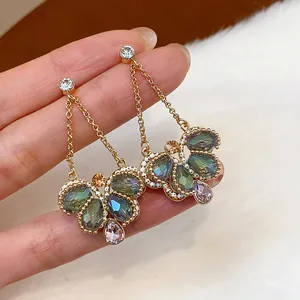 Detailed view of elegant gold-toned butterfly dangle earrings with colorful teardrop crystals.