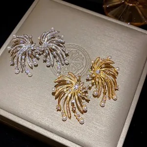 Elegant firework-shaped earrings with sparkling zircons and delicate white pearls.