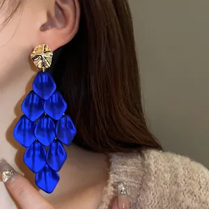 Detailed close-up of vibrant blue petal tassel geometric drop earrings worn by model