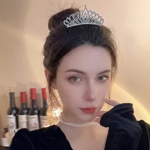 Elegant silver rhinestone crown tiara worn by a model for wedding and party hair accessories