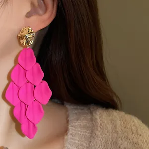 Close-up of elegant pink petal tassel earrings with a gold irregular top stud.