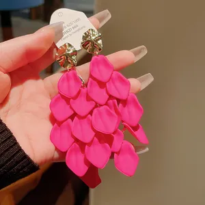 Detailed view of vibrant pink layered petal tassel earrings with textured gold accents