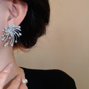 Close-up view of elegant silver fireworks earrings with shimmering zircons and pearls