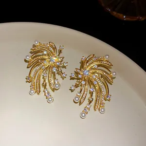 Macro view of gold-plated firework shaped stud earrings with sparkling zircon and white pearls
