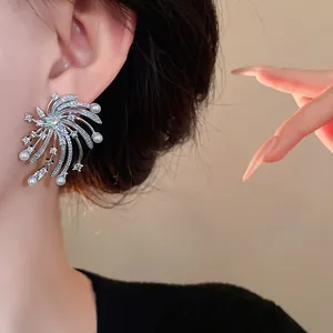 Close-up view of elegant zircon firework stud earrings with pearl accents on ear.