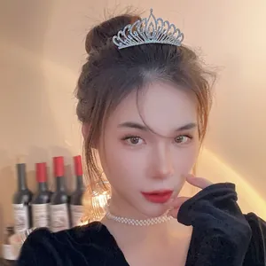 Elegant silver tiara with pearls and rhinestones worn by a model for a wedding party look.