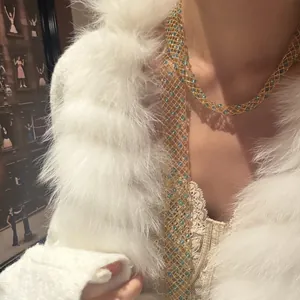 Elegant long gold mesh necklace with blue glass beads on model with fur coat