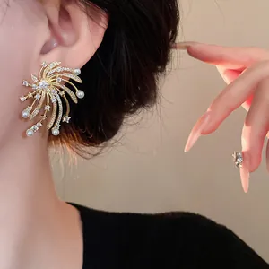 Detailed view of elegant firework stud earrings with zircons and pearls on a model.