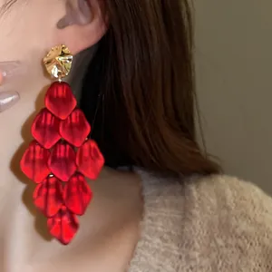 Macro view of elegant long red petal tassel earrings worn by a fashion model detail