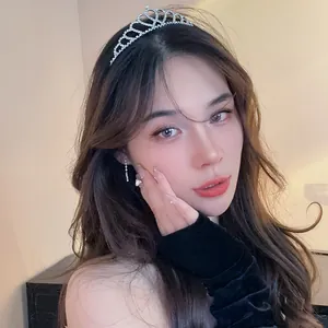 Elegant rhinestone tiara headband worn by a model for wedding or party hairstyles.