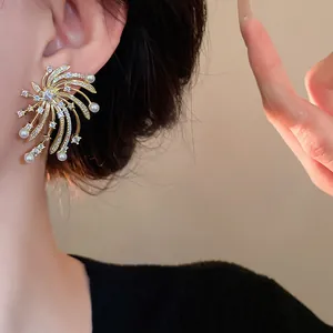 Close-up view of firework starburst earrings featuring pearls and shimmering zircons