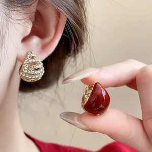 Close-up of vintage red enamel and pavé rhinestone water drop earrings