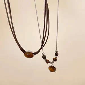 Primo piano dettagliato della collana vintage in occhio di tigre con finitura dorata.