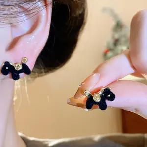 Detailed view of elegant black flocked horse stud earrings with gold metallic accents