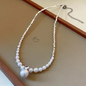 Detail of a French luxury zircon and artificial pearl necklace with crushed silver chain.