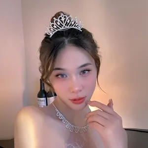 Close-up of an elegant pearl rhinestone crown and matching necklace set on a bridal model