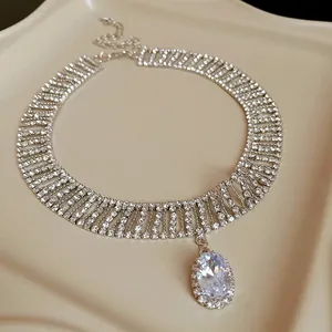 Macro view of a luxury silver necklace with tiered rhinestones and an oval crystal pendant