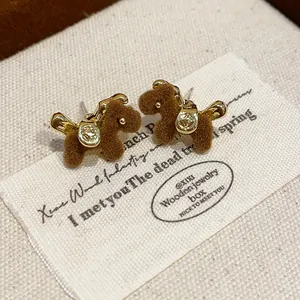 Close-up of retro flocking horse stud earrings with gold metallic details