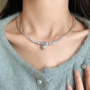 Close-up of elegant zircon and pearl pendant necklace with silver beads on a model.