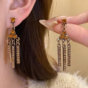 Vintage style dangle earrings with amber rhinestones and tassel design