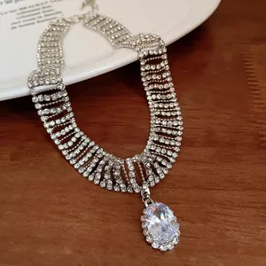 Close-up of a sparkling silver rhinestone choker necklace with a large oval zircon pendant.
