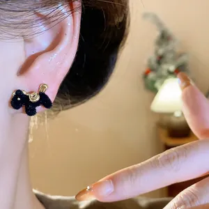 Close-up detail of black flocking horse stud earring with elegant gold-tone accents